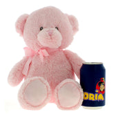 Pink plush teddy bear with a bow sits next to a blue soda can for size comparison.